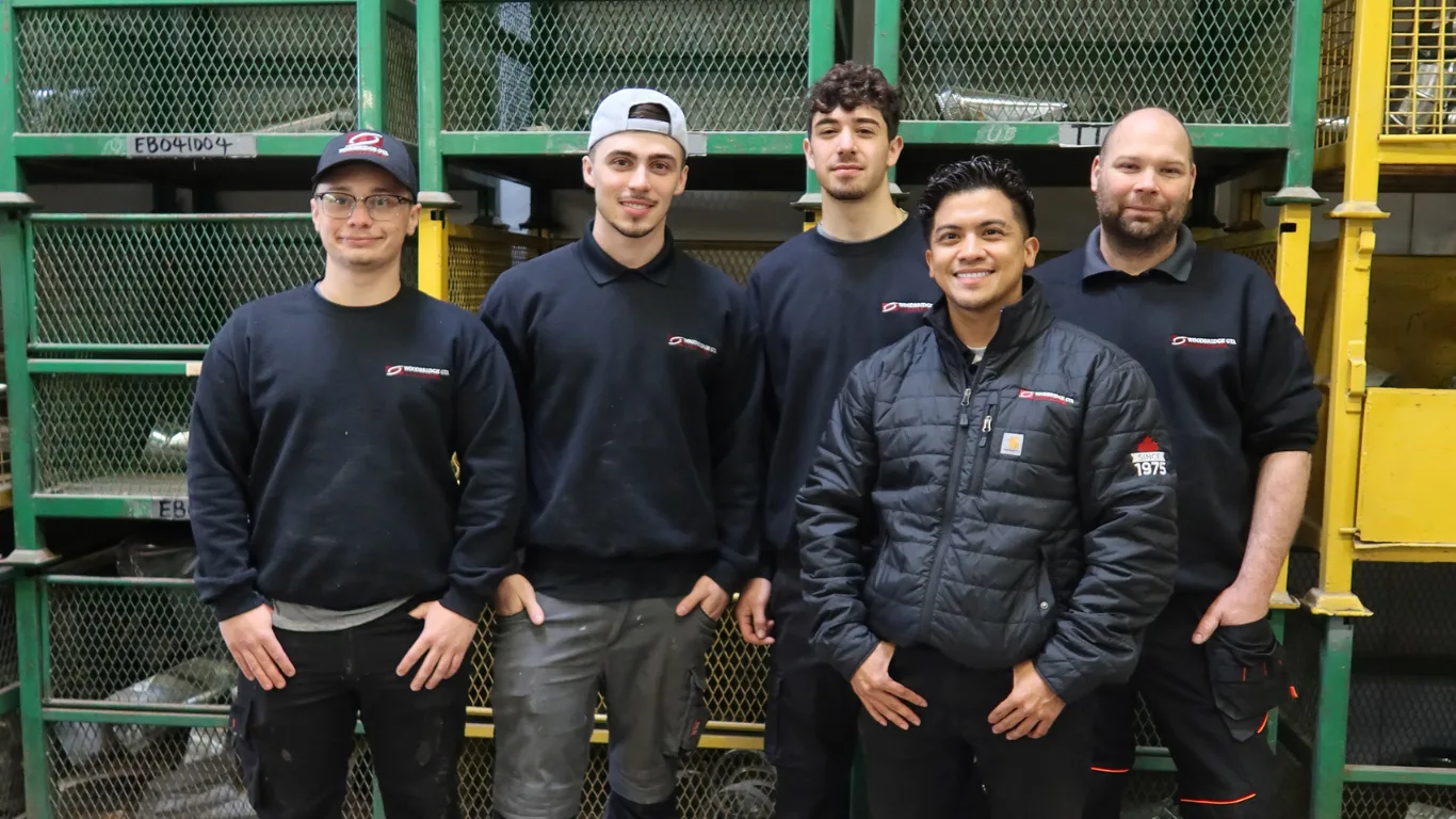 A group of five HVAC technicians posing for a team photo.