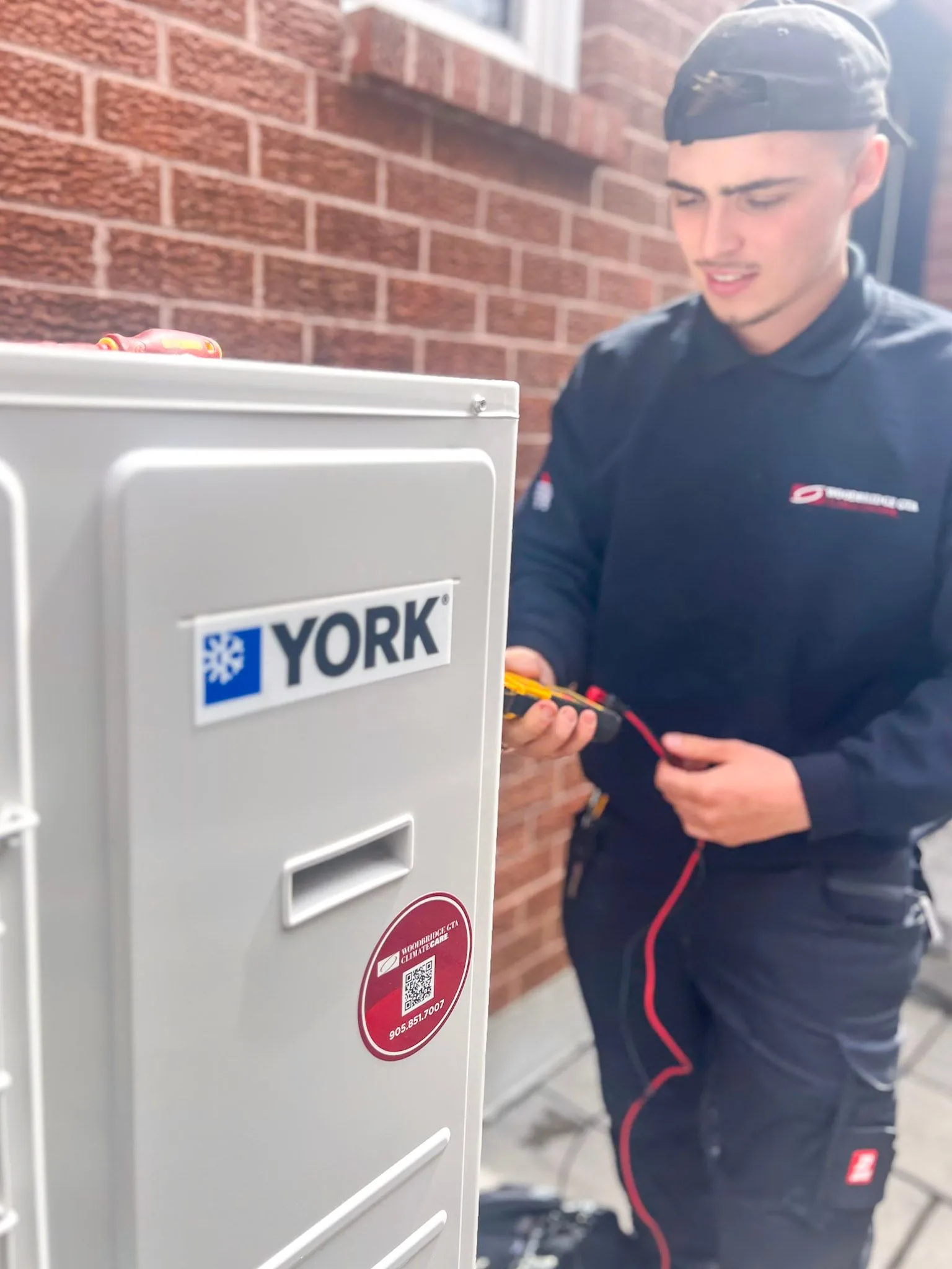Technician servicing a YORK HVAC unit outdoors.