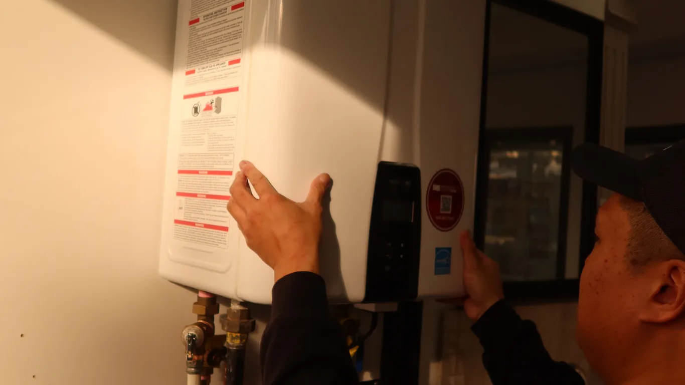 Technician installing a tankless water heater in a home.