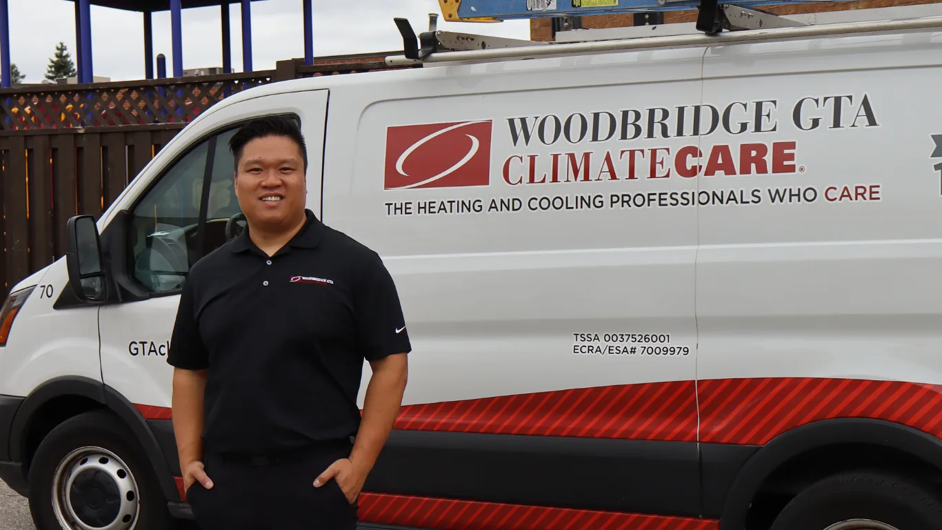 A man beside a HVAC service van with branding.