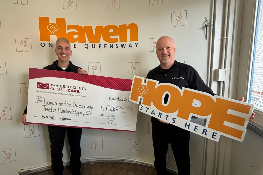Men presenting a donation check in front of a company logo.