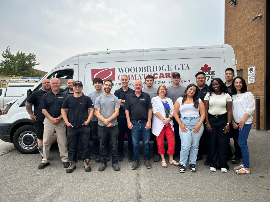 A diverse team of HVAC professionals in front of a service van.