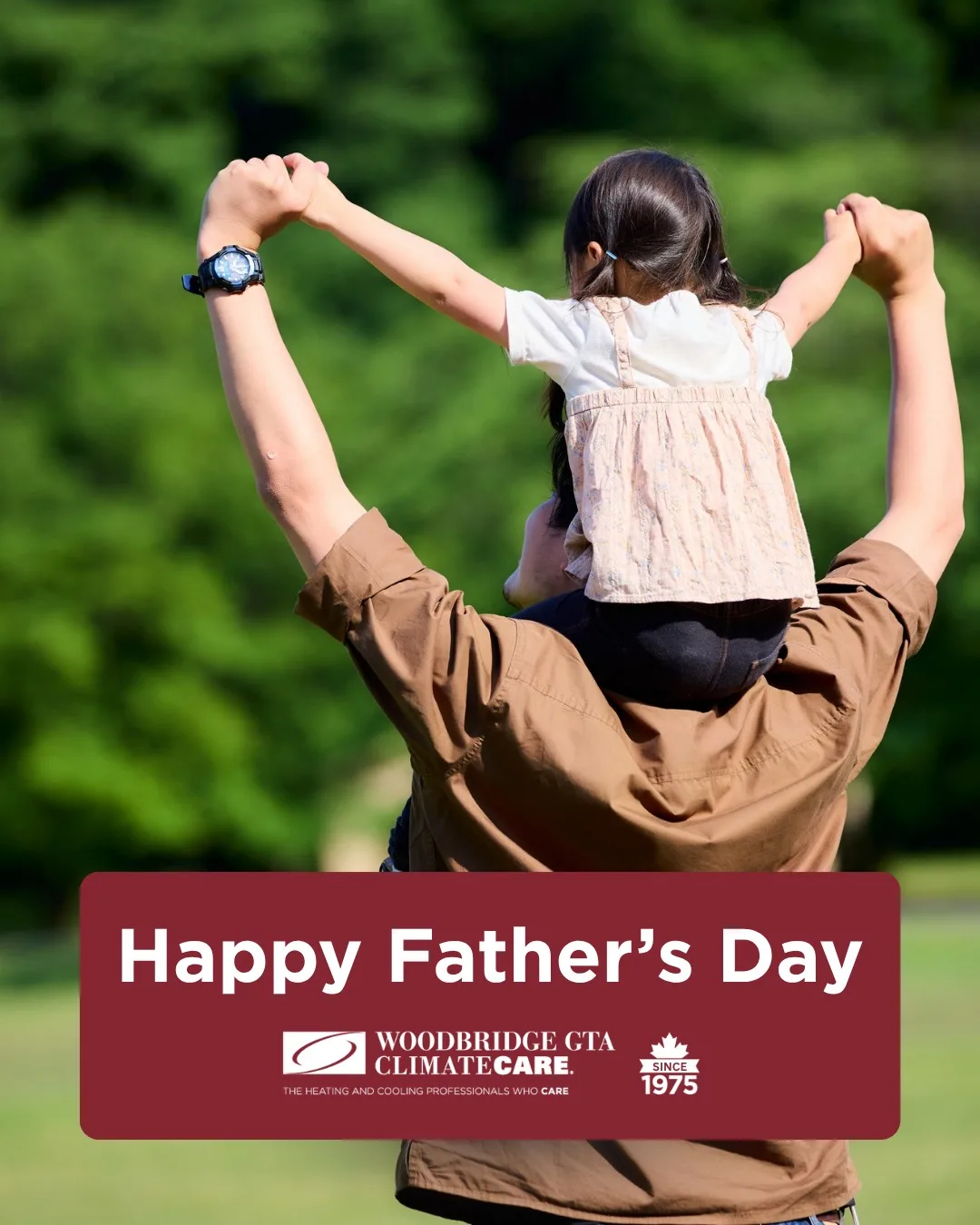 Father carrying daughter on shoulders outdoors.
