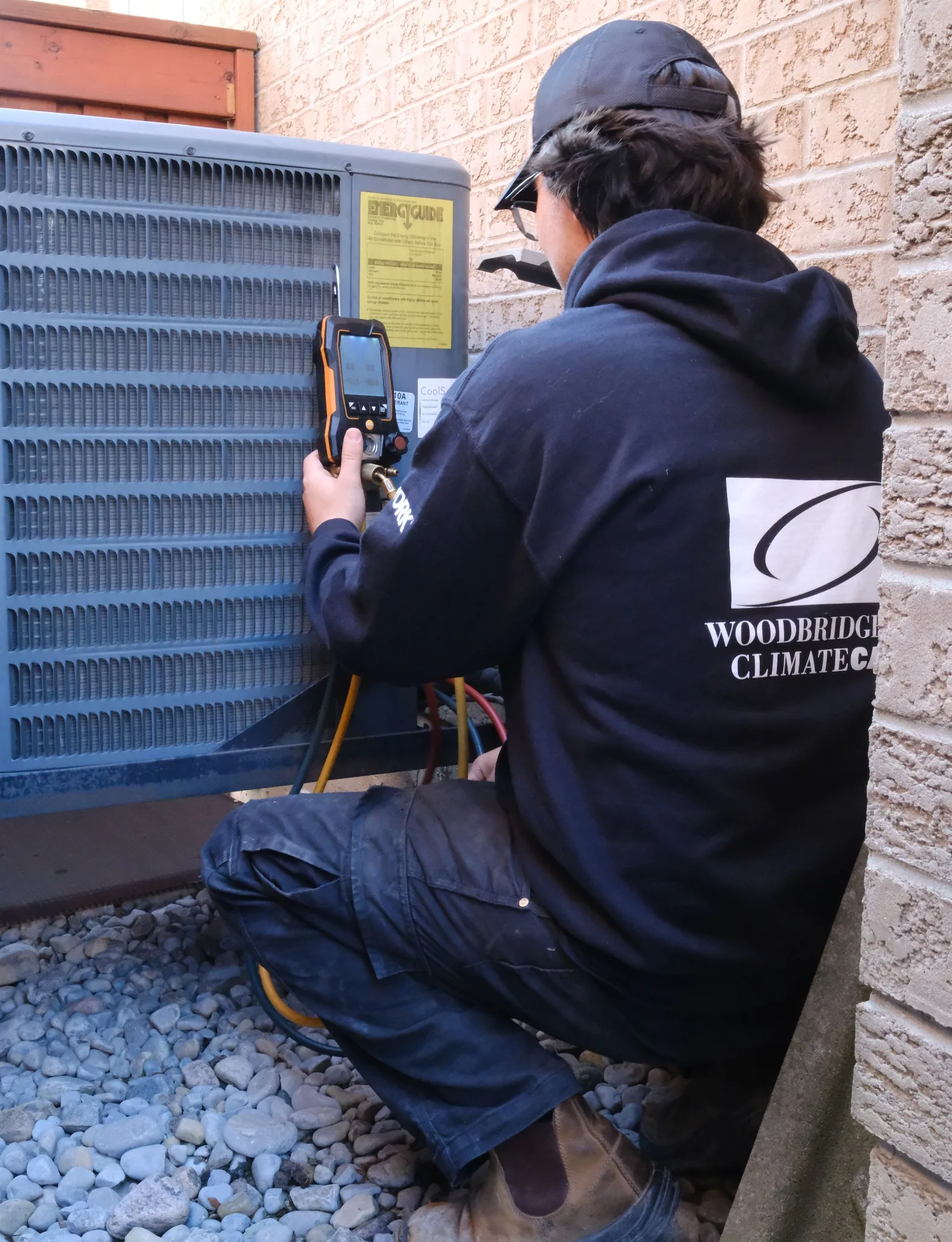 A technician inspecting an HVAC unit outside.