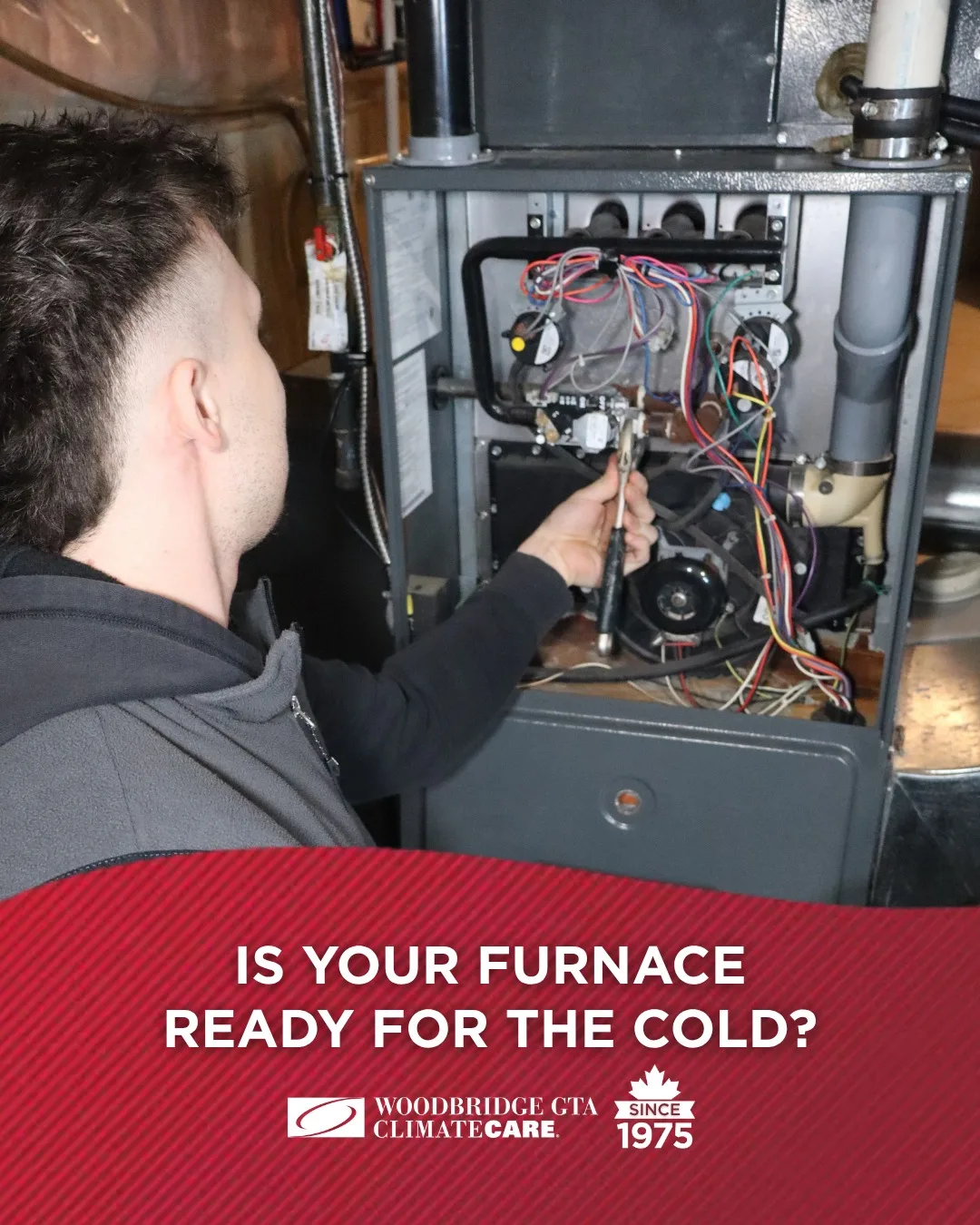 A technician inspecting a furnace in a utility room.