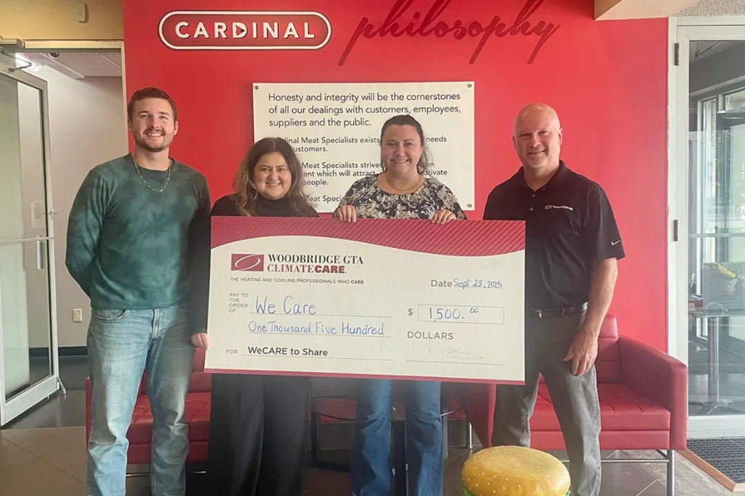Group with a large check donation inside an office.