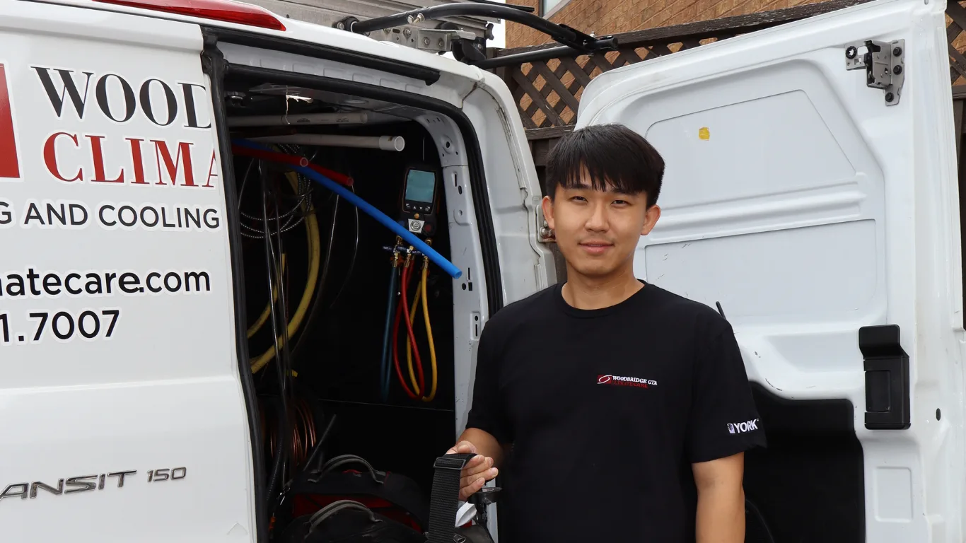 HVAC technician with tools next to a service van.