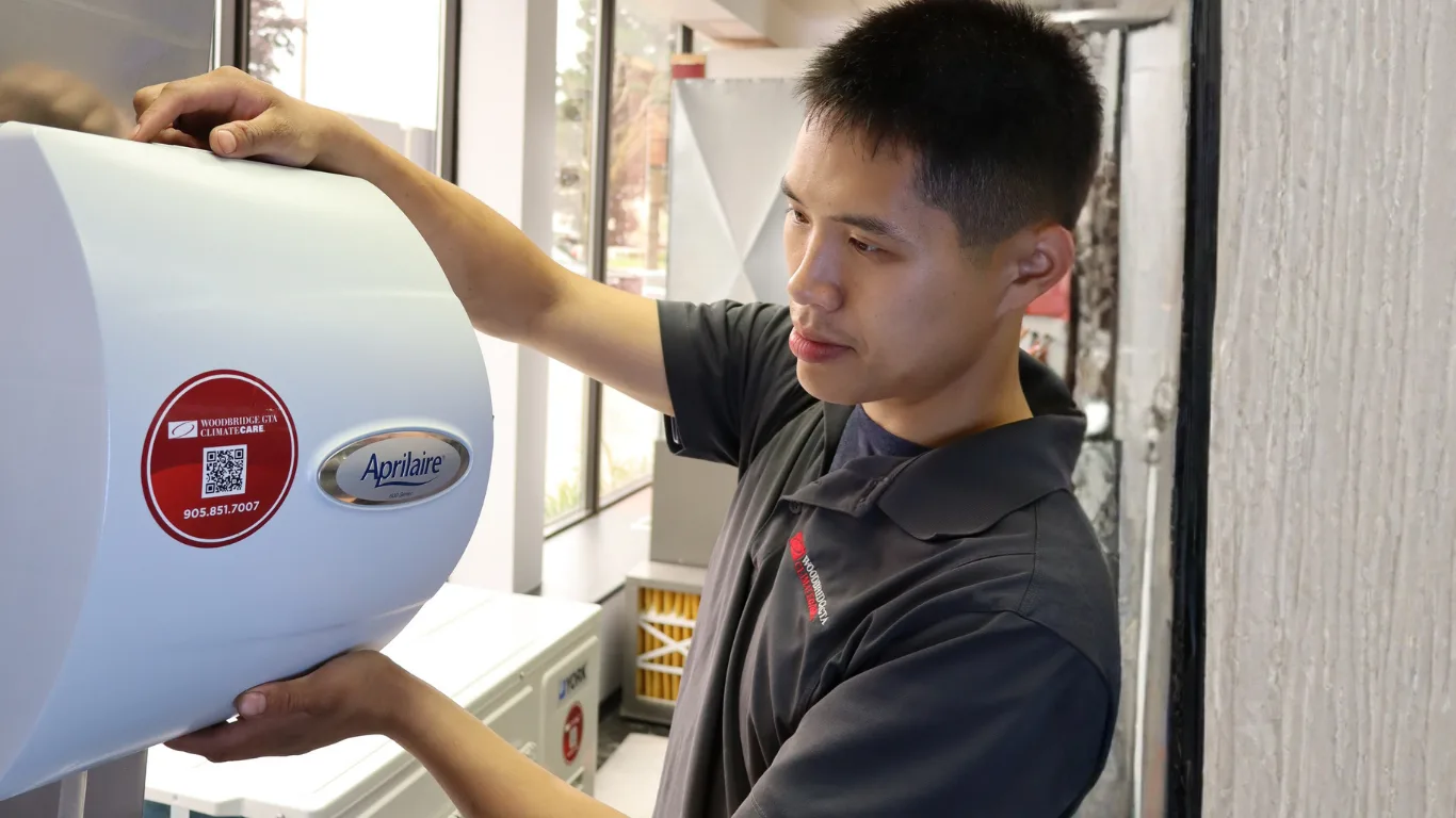 A technician installing an Aprilaire air quality system.