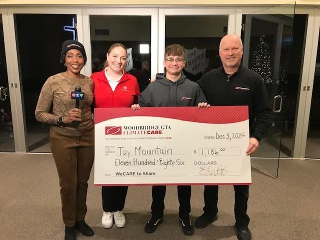 Group holding a large check for charity at an event.