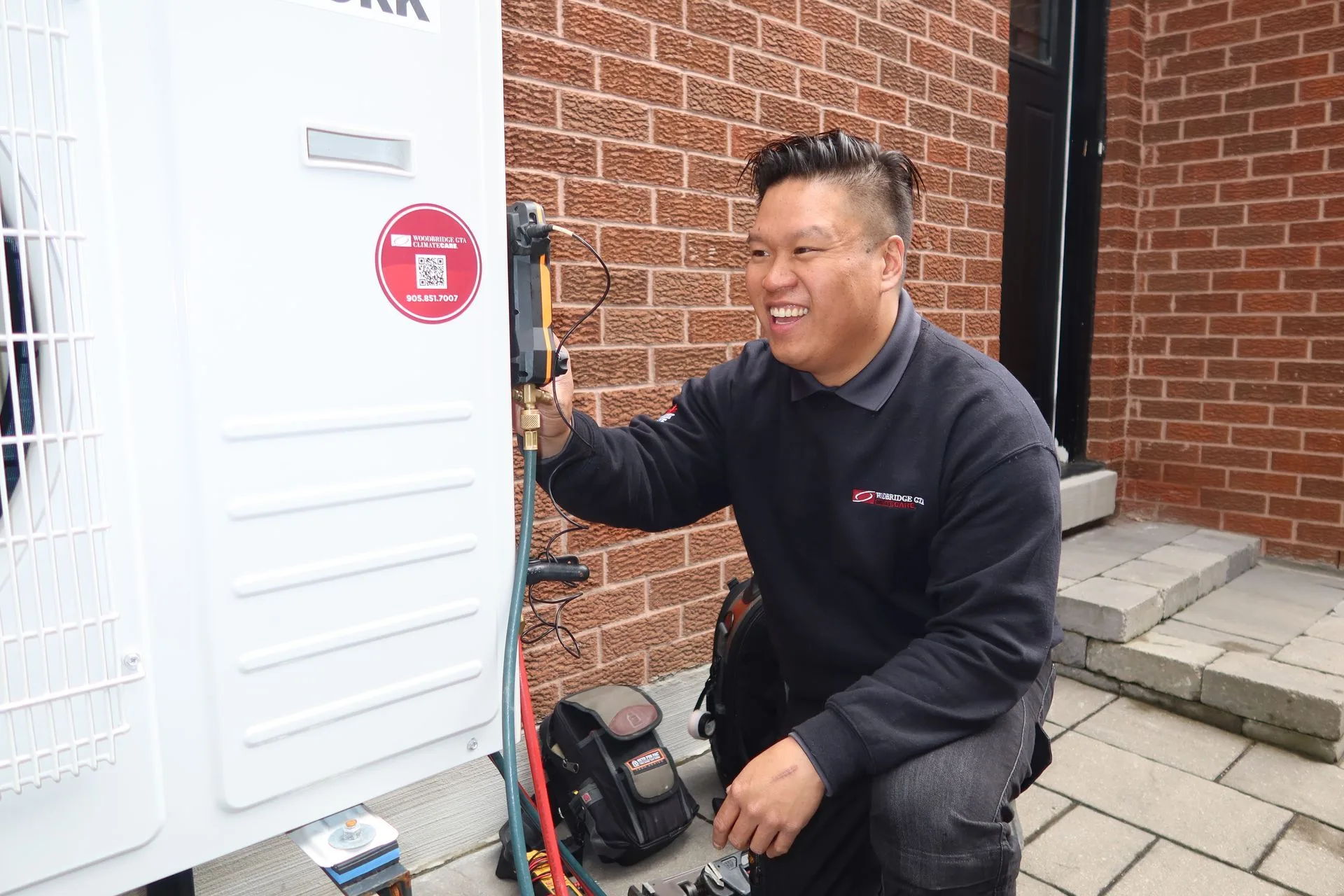 A technician servicing an HVAC unit outside a building.