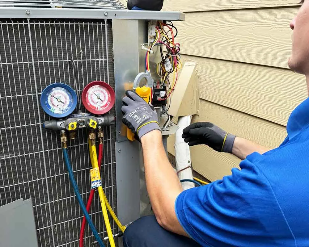 A technician servicing an outdoor HVAC unit.
