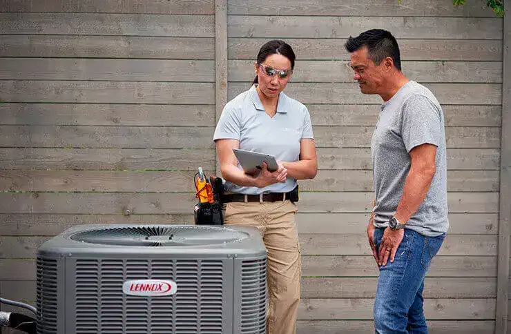 Technician consulting with a homeowner about air conditioner installation.