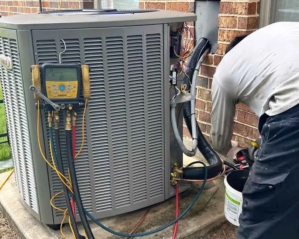 Technician servicing an outdoor HVAC unit.