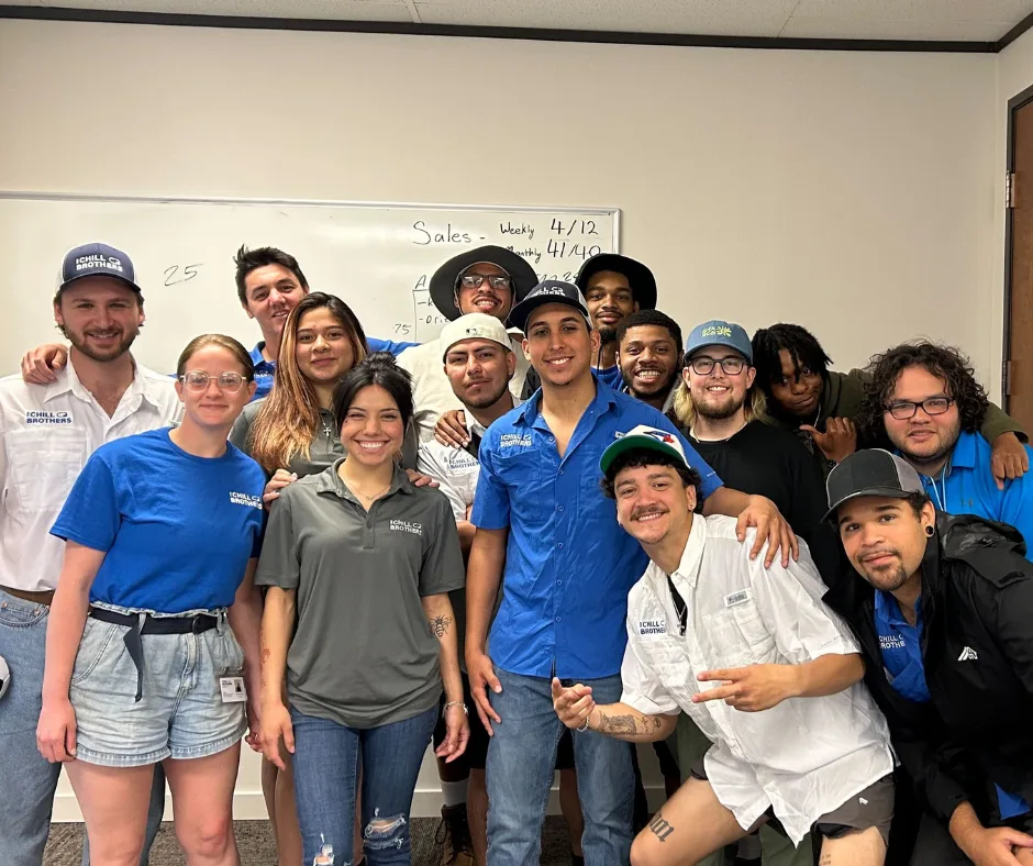 A group of HVAC technicians in uniforms smiling together.