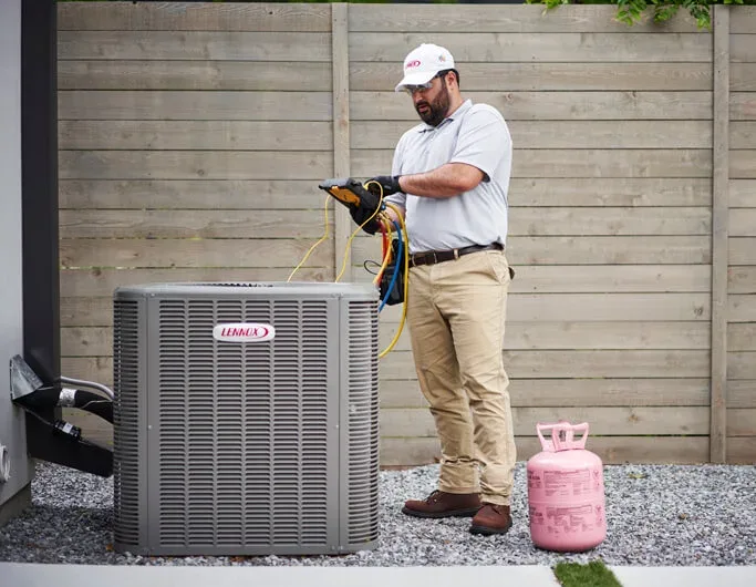 HVAC technician servicing an air conditioning unit outdoors.