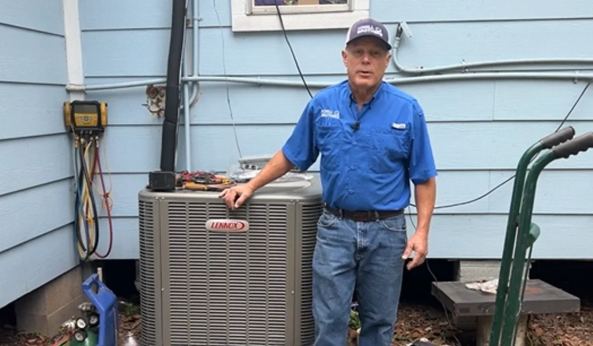HVAC technician with Lennox air conditioning unit outside a house.