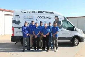HVAC technicians in front of a Chill Brothers van.