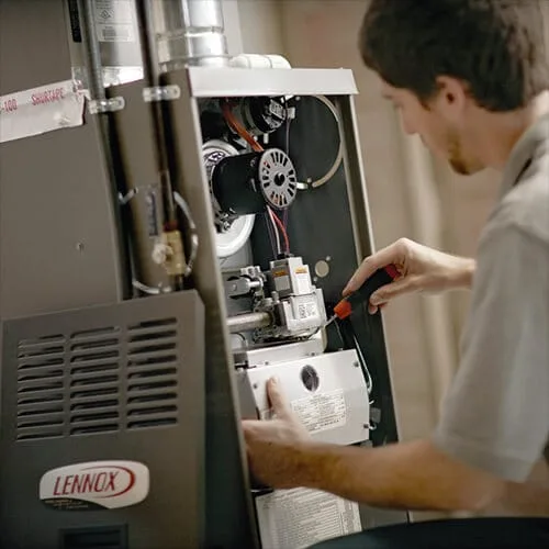 Technician servicing a Lennox furnace unit.
