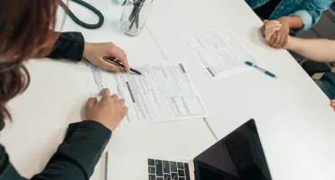 A person completing legal paperwork at a table.