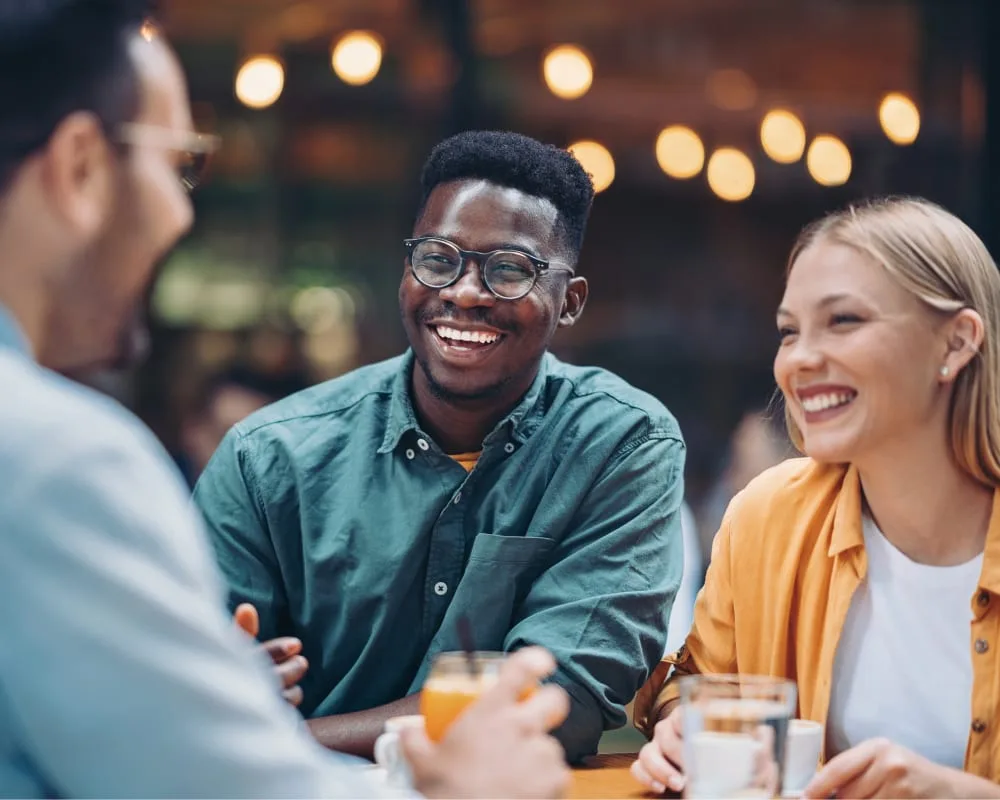Three friends enjoying a conversation over drinks.