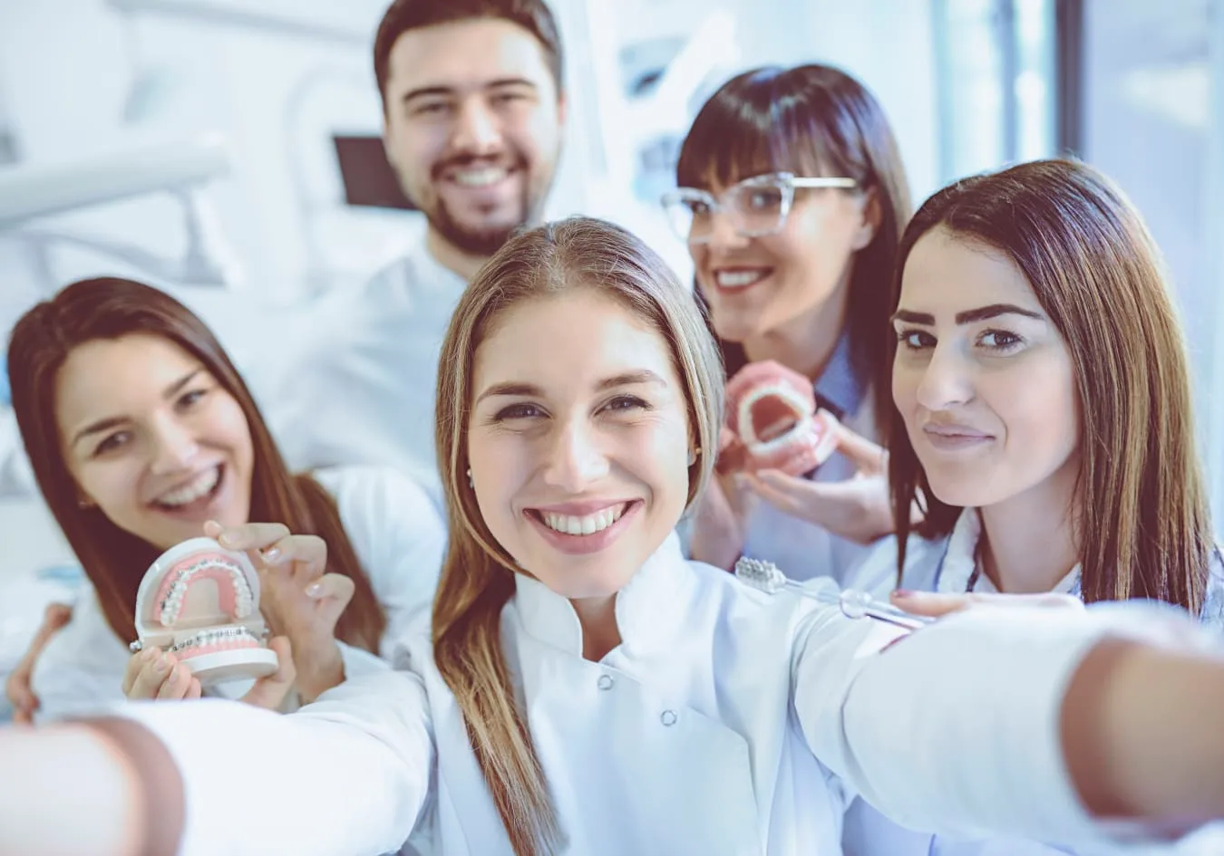 A group of smiling dental professionals in a clinic setting.