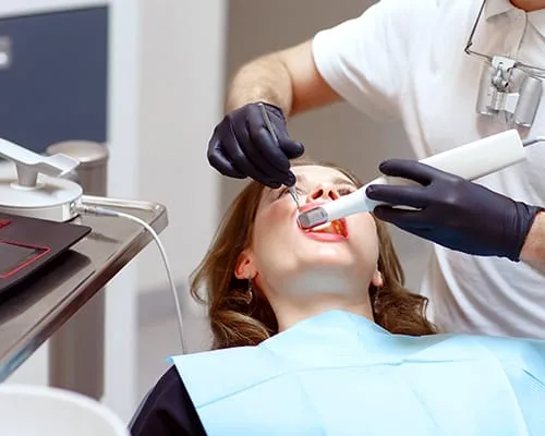 A dental professional using a digital scanner on a patient.