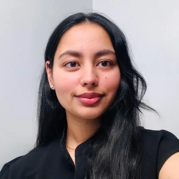 A young woman smiling with long black hair.