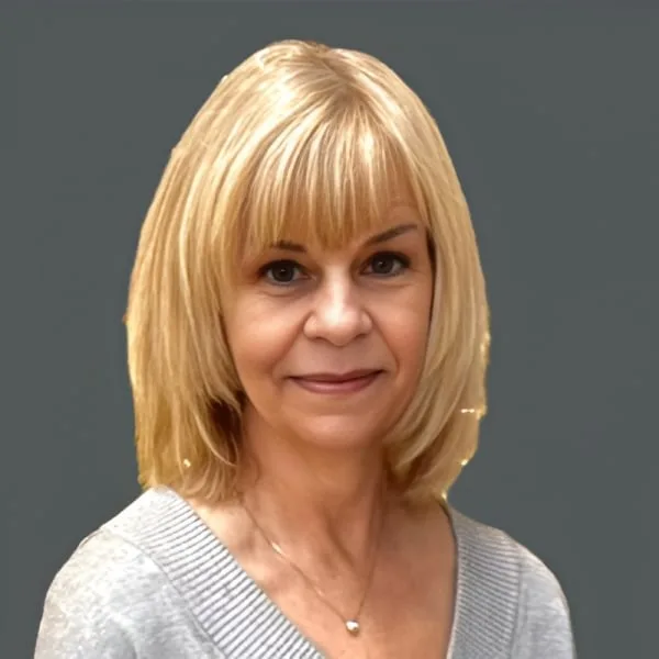 Smiling woman with blonde hair in a gray sweater.
