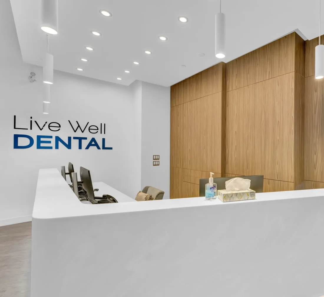 A modern dental office reception area with wooden panels and a counter.