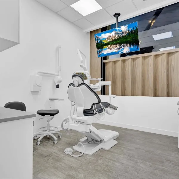 Dental examination room with a modern chair and window view.