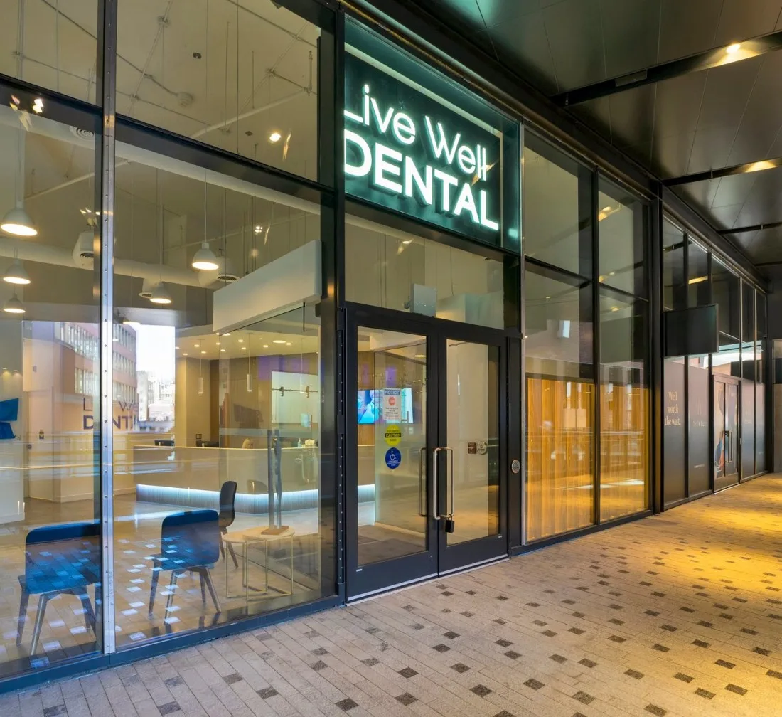 Exterior view of Live Well Dental clinic with illuminated sign.