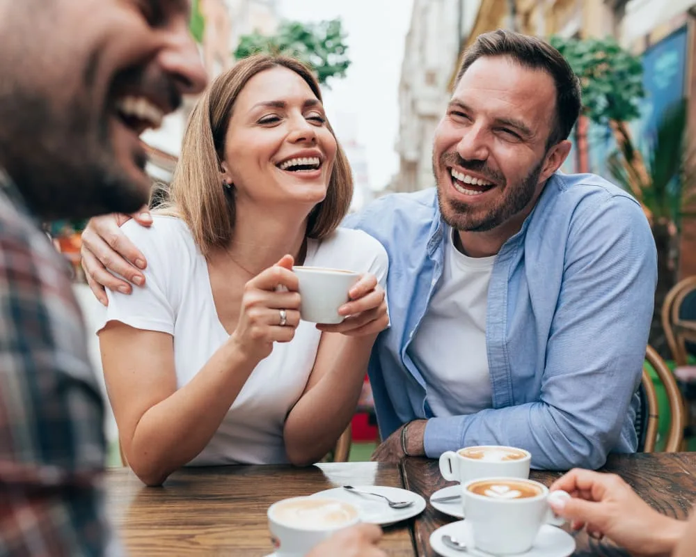 A group of friends enjoying coffee and laughter at a cafe.