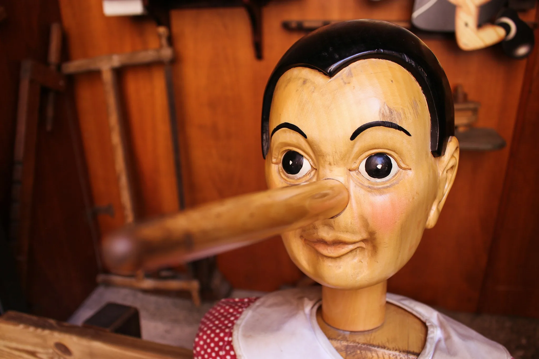 A wooden marionette with a long nose and painted face.