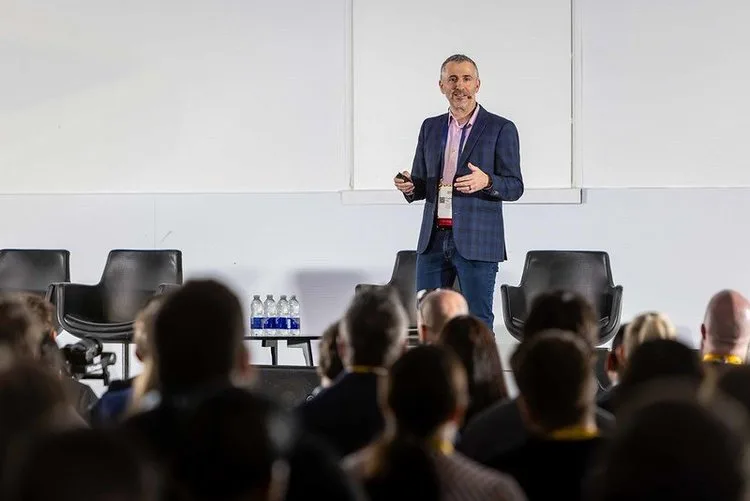 A speaker presenting to an audience at a conference.