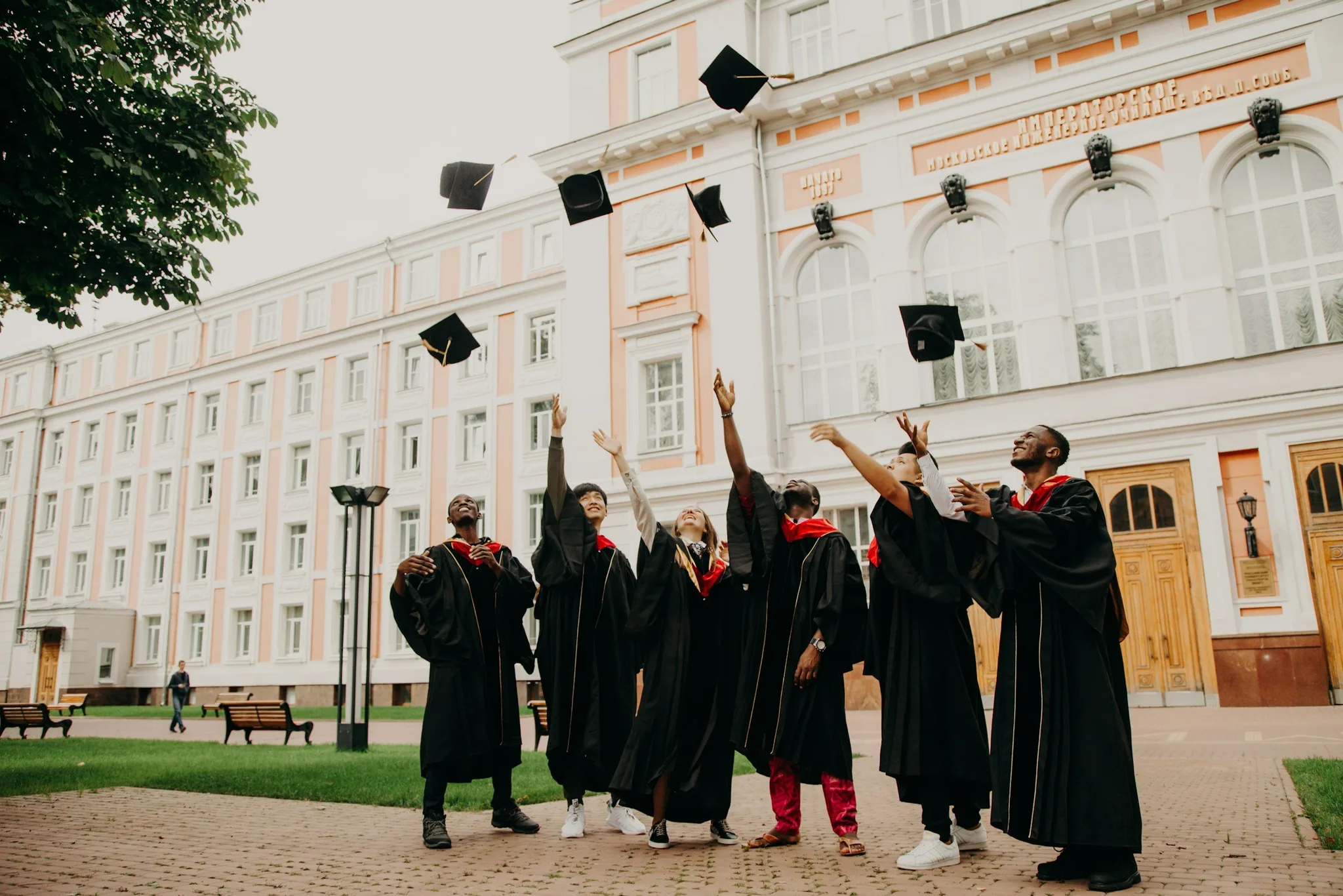 Graduates celebrating by throwing their caps in the air.