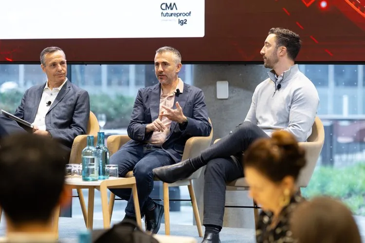 Three men on a panel discussing at an event.