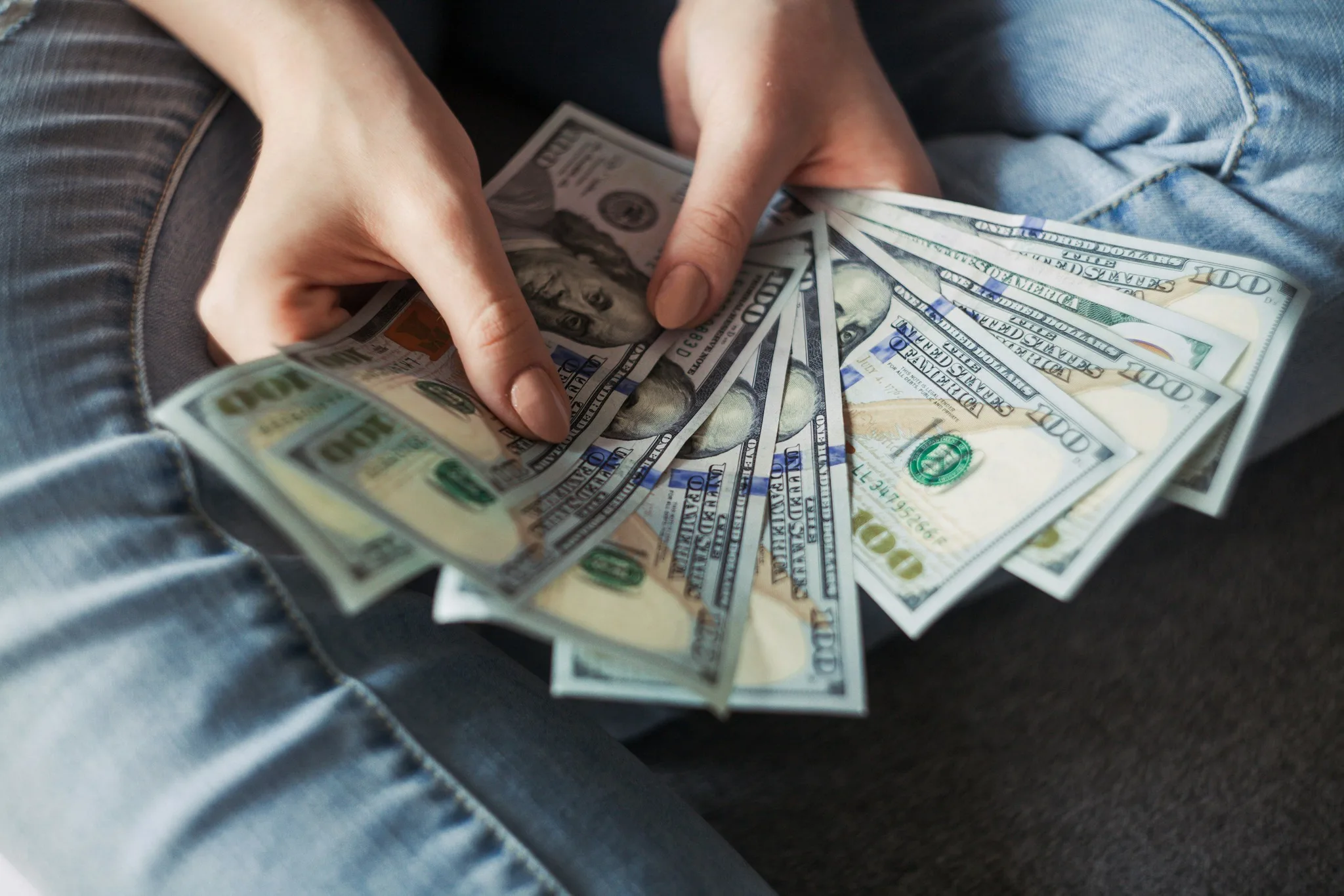 Person holding a fan of twenty-dollar bills.