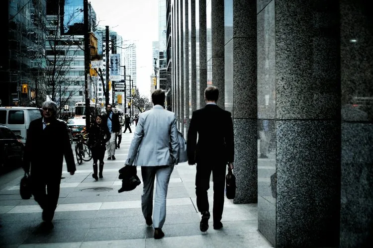 Business professionals walking on a city sidewalk.