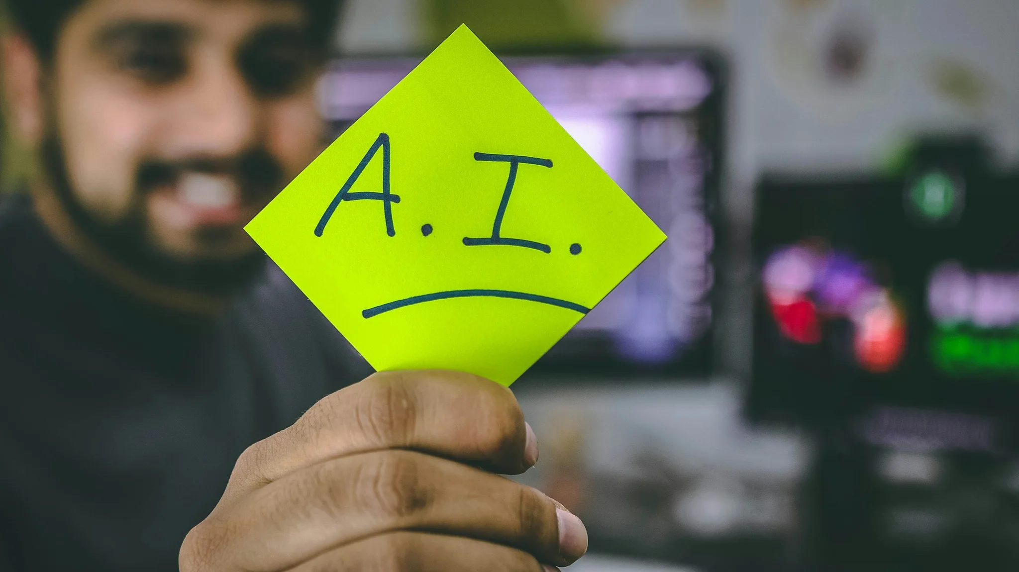 Person holding a sticky note with A.I. written on it.