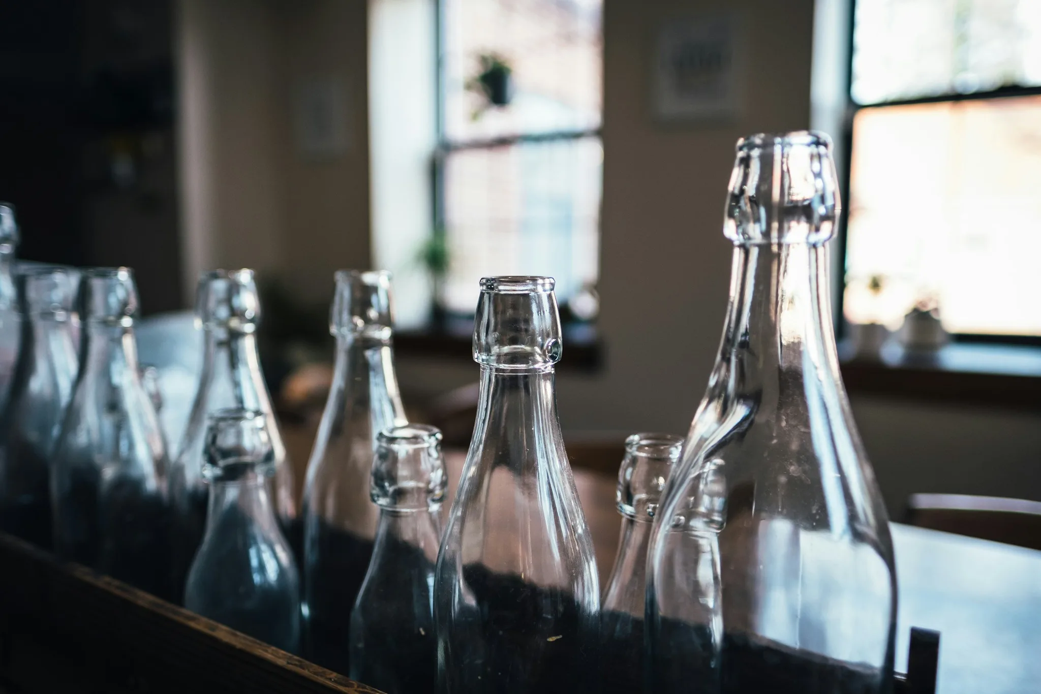 A collection of clear glass bottles on a wooden surface.