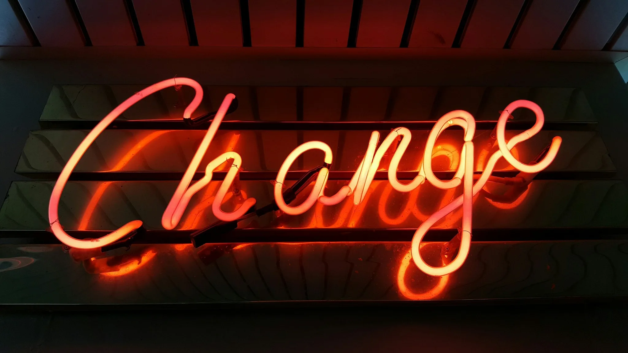 Neon sign reading 'Change' in cursive letters.