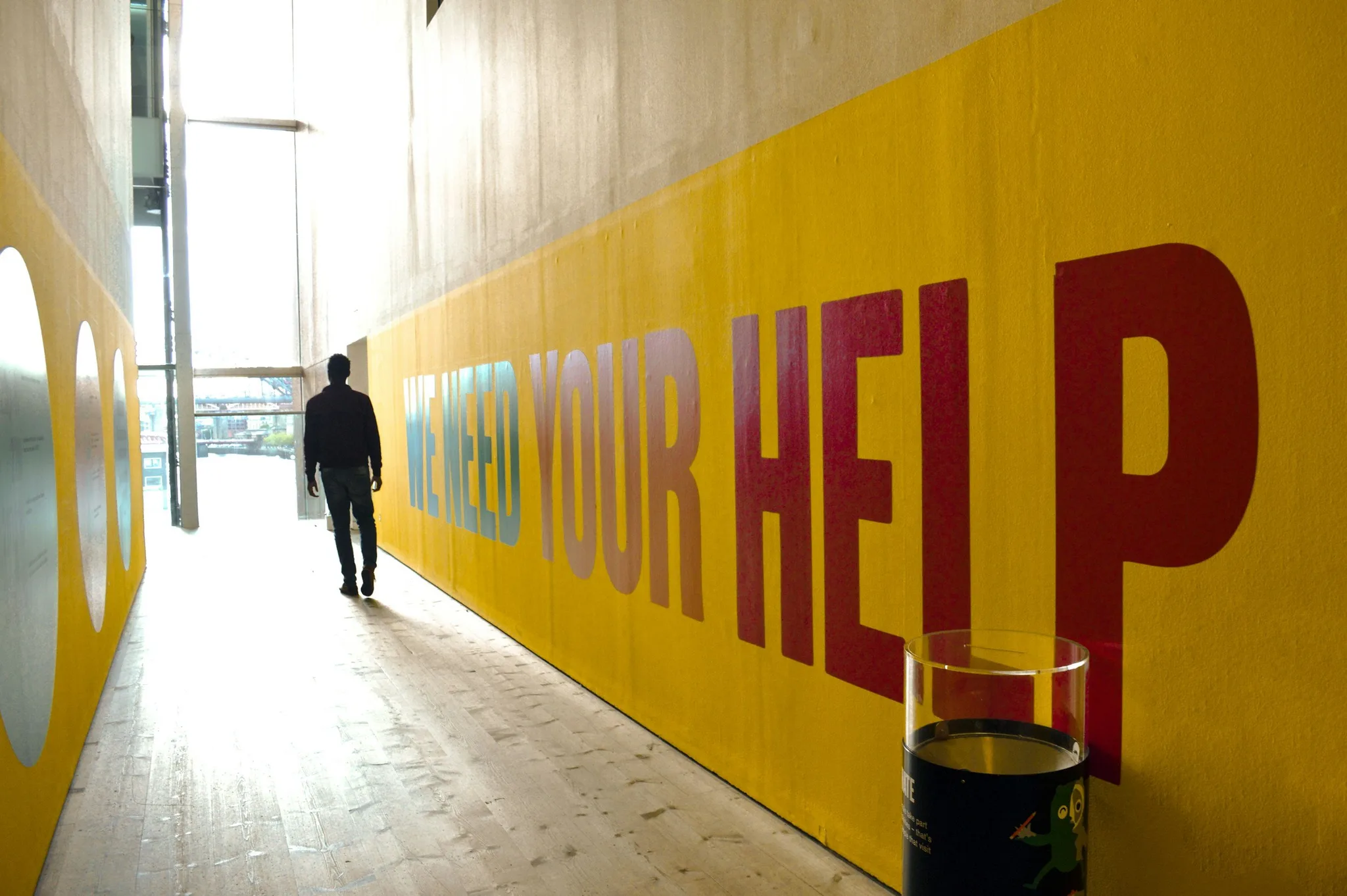 A person walking through a hallway with a mural.
