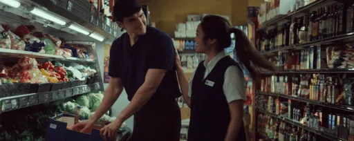 Two grocery store employees engaged in conversation.