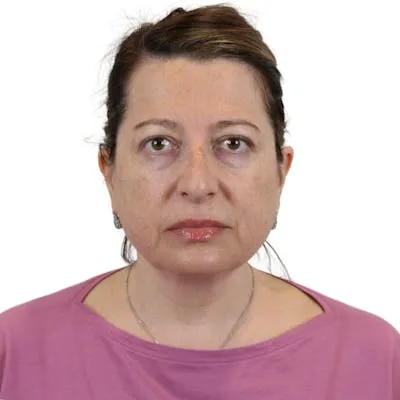 A woman in a pink top looking at the camera.