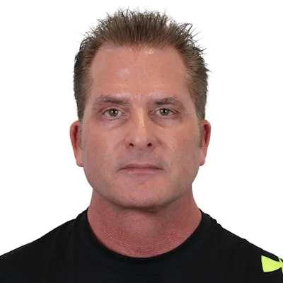 A middle-aged man with short styled hair in a black shirt.