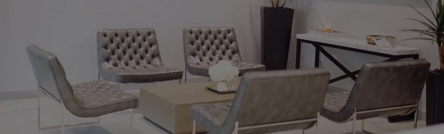 A modern waiting area with tufted gray chairs and a coffee table.