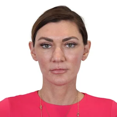 A woman in a bright pink top with a neutral expression.