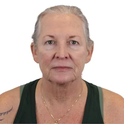 A middle-aged woman with gray hair looking straight at the camera.