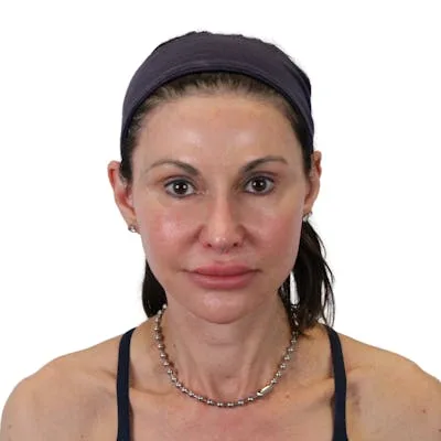 A woman with a headband and necklace posing for a photo.