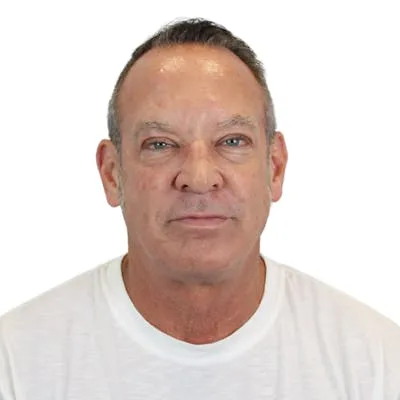 A man in a white shirt facing the camera.